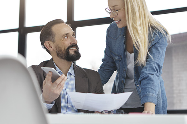 Frau unterhält sich mit Kollegen im Büro